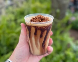 A close-up shot of Kristoff Kaffe, showcasing its rich and creamy texture, with coffee-chocolate sauce beautifully swirled on top, enticing coffee lovers to indulge in this delectable treat.